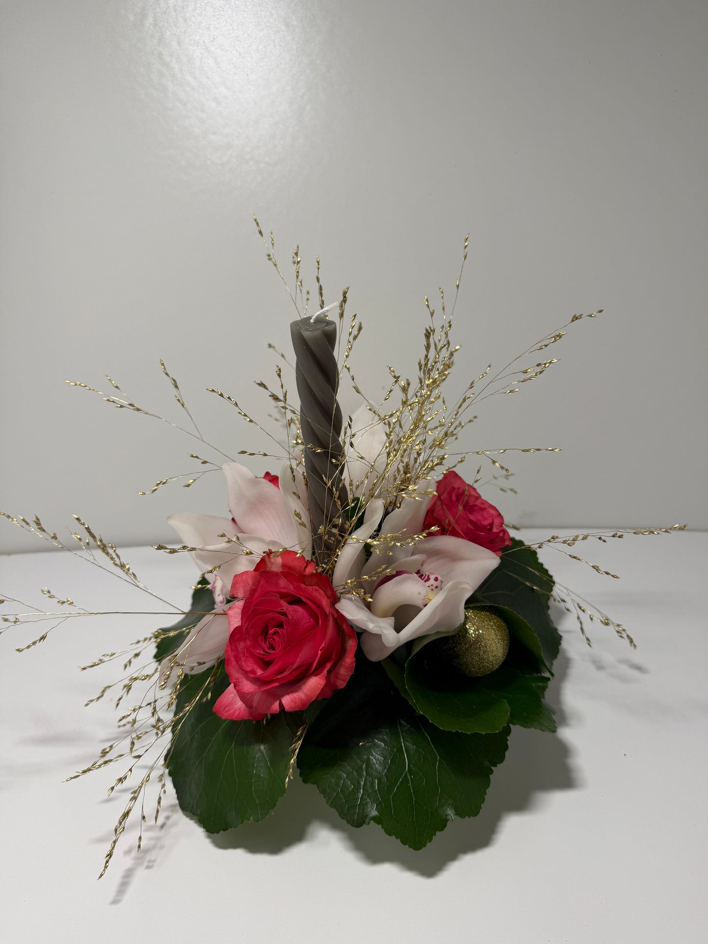 Centre de table festif rose et orchidée avec bougie torsadée